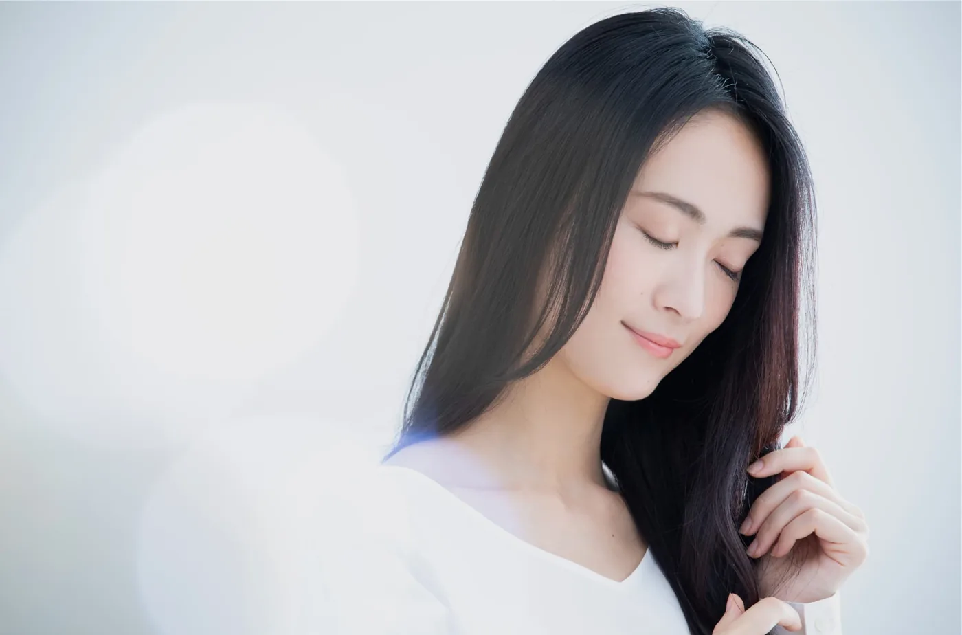 自然な艶のある髪に触れる女性